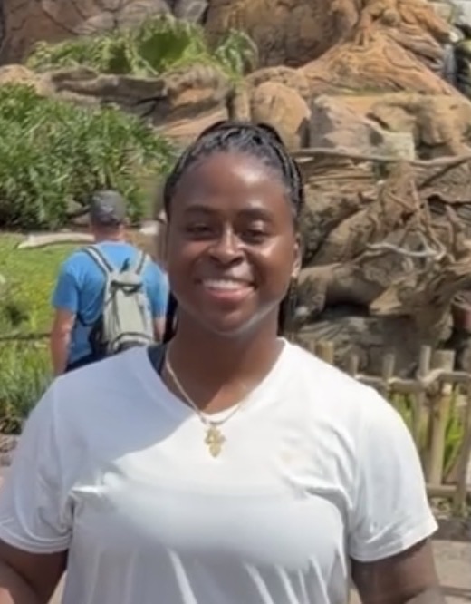 Ashley, who runs Ashley Motion, smiling outdoors in a white t-shirt